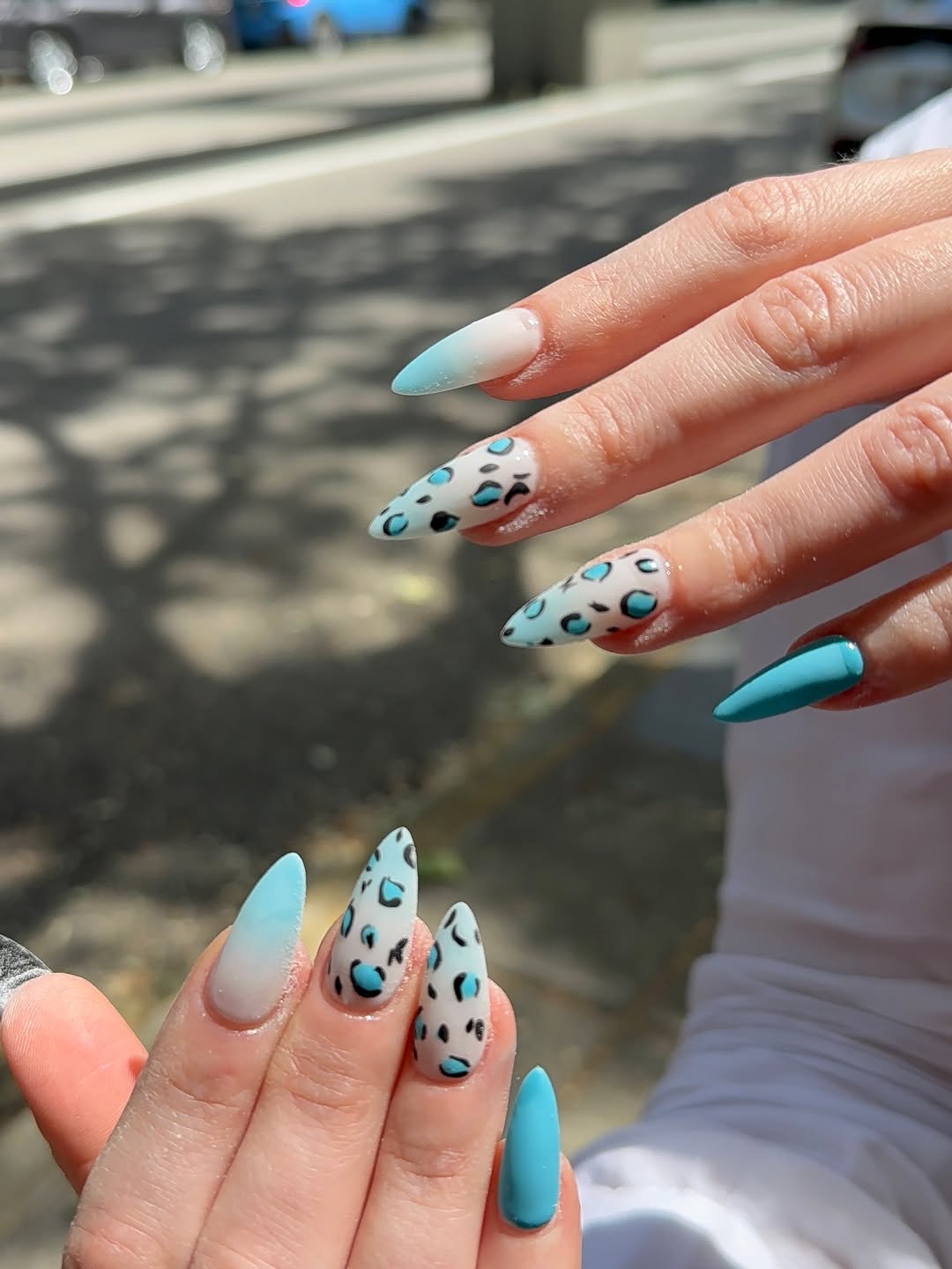 White nails with intricate hand-drawn blue floral linework